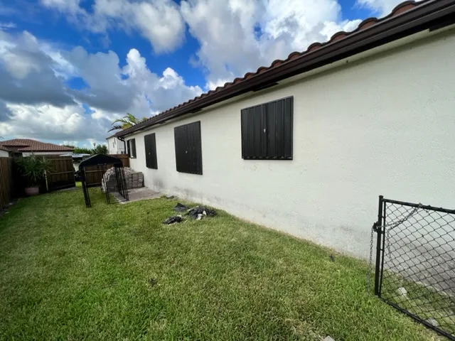Black accordion shutters on side of home