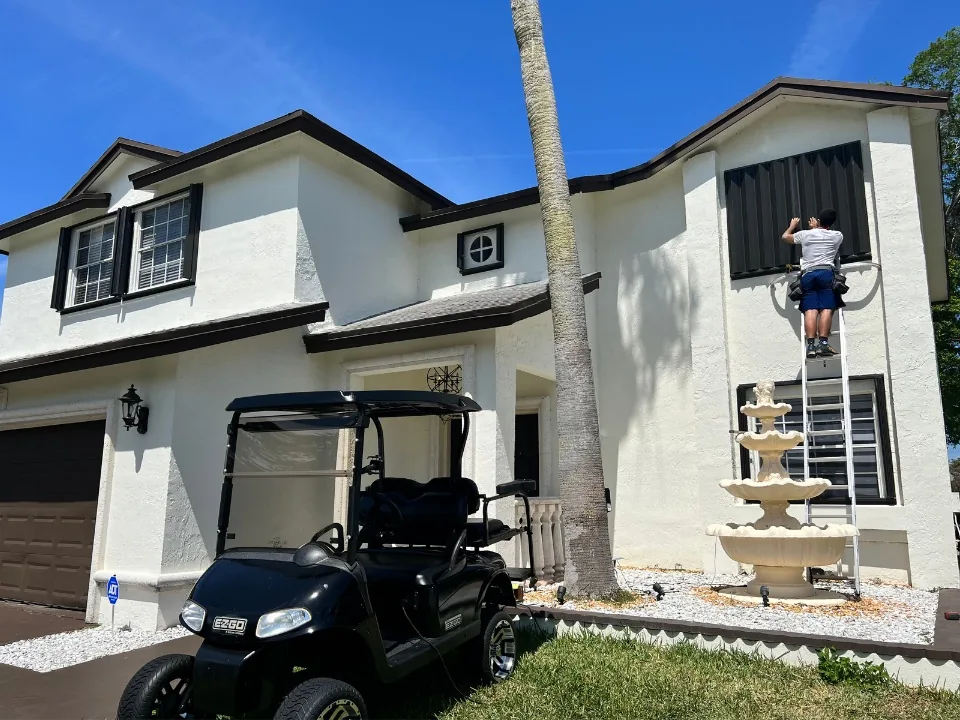 Black accordion shutters on a two-story home